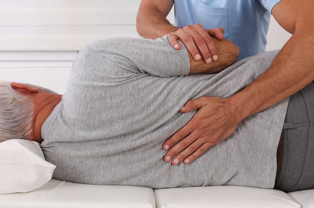 Person gently stretching the neck beside a headache diary, water glass, and soft indoor light.